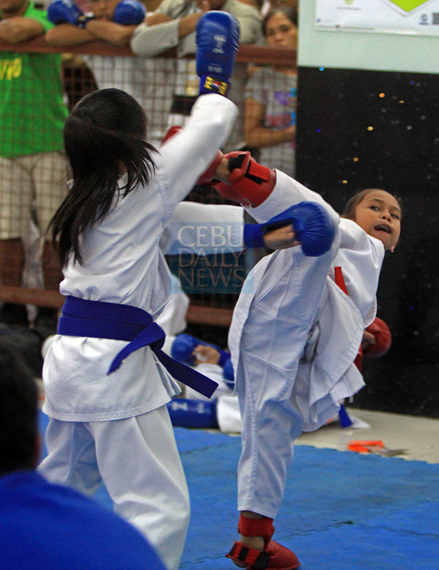 Janine Narboada (right) of Cebu Province connects with a kick to Cebu City's Loreen Alexa Parantar whom she beat in the Batang Pinoy taekwondo event. (CDN PHOTO/LITO TECSON)