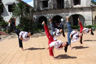 Taekwondo students executes difficult synchronized routine.
