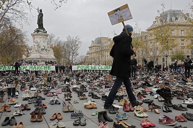 A man walks between shoes as hundreds of pairs of shoes are displayed at the place de la Republique, in Paris, as part of a symbolic and peaceful rally called by the NGO Avaaz "Paris sets off for climate." (AP PHOTO)