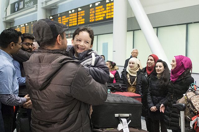 Six-year-old Ahmad Mazan Khabbaz, , a refugee from Syria, smiles as he is greeted by family friend Rakan Almasri, himself a recent arrival to Canada from Syria.  The boy  arrived with his parents and sisters  at Toronto’s  Pearson International Airport on Wednesday (AP PHOTO)