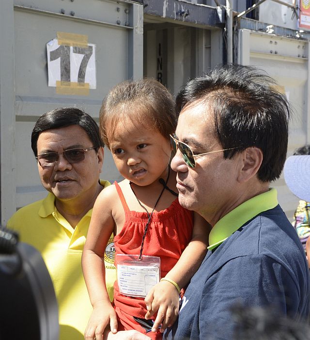 Suspended Cebu City Mayor Michael Rama (right) carries Niña Dayday, who was born in a container van in the Devotee City five years ago.  With them is Acting Cebu City Mayor Edgardo Labella. (CDN PHOTO/CHRISTIAN MANINGO)