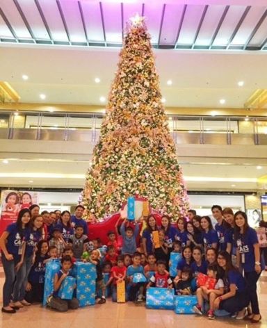The children beneficiaries with SM City Cebu mall employees under the Christmas Tree at the Northwing.