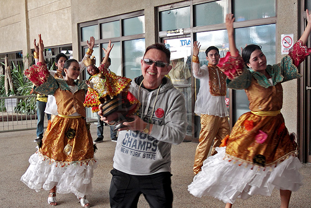 A balikbayan joins the Sinulog dancers at the Mactan-Cebu International Airport in this January 2014 photo. (CDN FILE PHOTO)
