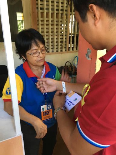 A delegate of the IEC examines a security band attached to his right wrist by a volunteer. (CDN PHOTO/EILEEN G. MANGUBAT)