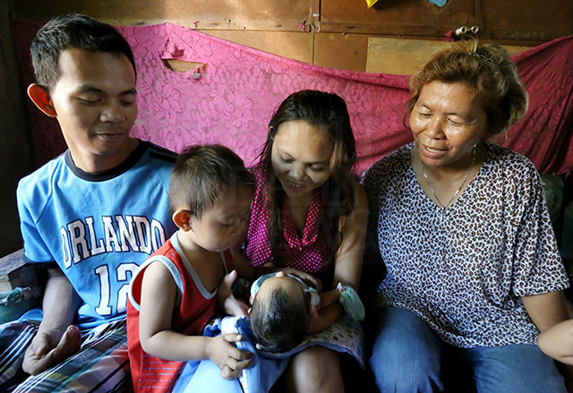 Jonathan Celadania and wife Jayvee happily reunite with their newborn baby Prince Nino and son Jaythaniel in their house in barangay Tungkop, Minglanilla with their mother Patricia Celadania (right) after they recovered baby Nino from kidnapper Melissa Alilin Londres. (CDN PHOTO/JUNJIE MENDOZA)