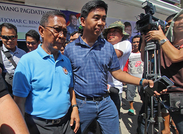 Former Makati City mayor Junjun Binay shields his father Vice Pres. Jejomar Binay from the media during the opening of the UNA headquarters in Mandaue City. (CDN PHOTO/TONEE DESPOJO)