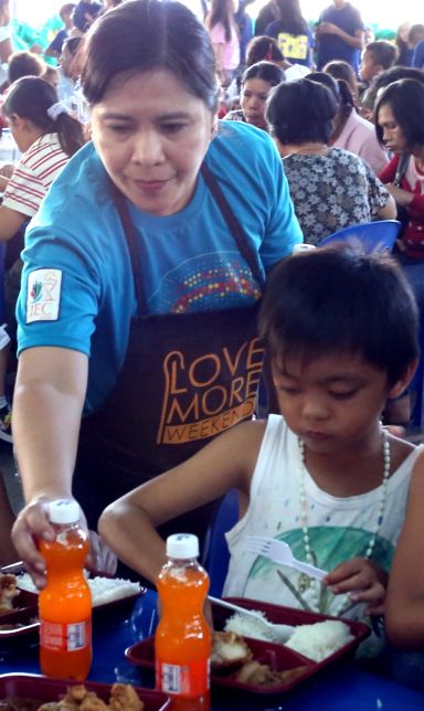 A volunteer from the Couples for Christ serves food trays to urban poor children in the Table of Hope at the covered court of the Cebu Archdioces seminary. (CDN PHOTO/JUNJIE MENDOZA)