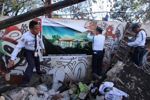 LAHUG FIRE/DEC 31,2015: University of the Philippines (UP) guards install tarps of a proposed school building that will be constructed at the Lahug fire site. (CDN PHOTO/TONEE DESPOJO)
