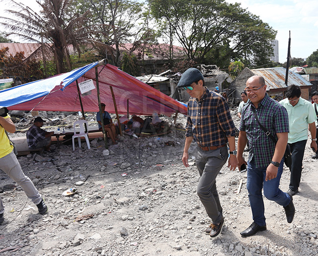 Suspended Cebu City Mayor Michael Rama (left) with Collin Rosell visits the fire scene in sitio Avocado and assures informal settlers they can go back to occupy the UP lot. (CDN PHOTO/JUNJIE MENDOZA)