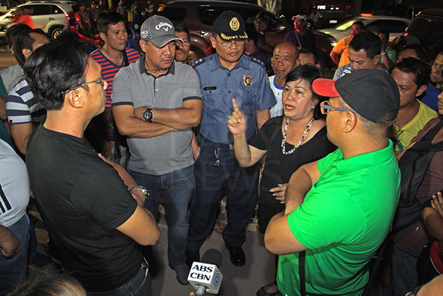 Cebu City Administrator Dr. Lucelle Mercado talks a UP Cebu representative (wearing black shirt and glasses), who came together with Supt. Rex Derilo (with gray baseball cap), chief of the Regional Special Operations Group and Supt. Clarito Baja (in uniform), head of the PRO-7 Police Community Relations Office, and tried to order the residents of sitio Avocado, barangay Lahug, who were busy delineating their areas to vacate the area. Standing with Mercado is Atty. Collin Rosell (right), head of Cebu City Hall's Division for the Welfare of the Urban Poor (DWUP). (CDN PHOTO/LITO TECSON)