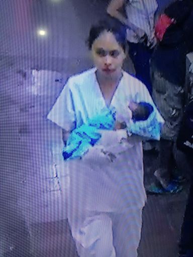 Images of the CCTV security camera capture an unidentified woman in white scrubs carrying baby Prince Nino Celadenia out of the Vicente Sotto Memorial Medical Center after getting the newborn infant from his mother on the pretext of bringing him to the laboratory for an anti-dengue shot. 