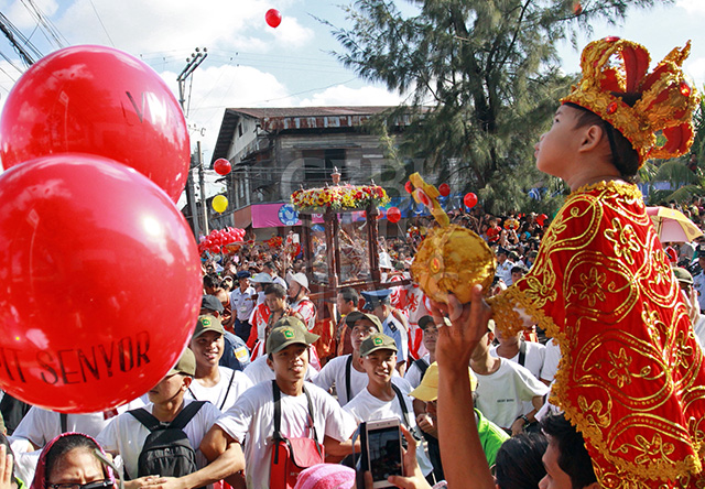 For the thousands who witness the procession, like this boy dressed like the Sto. Nino, are content to get a glimpse from afar when the icon arrives at Pier 1, Cebu City with Cebu Archbishop Jose Palma. (CDN PHOTO/LITO TECSON)