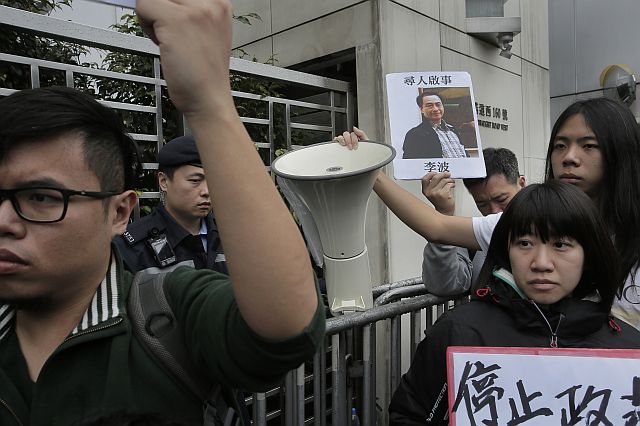 A protester holds a photo of missing bookseller Lee Bo during a protest outside the Liaison of the Central People’s Government in Hong Kong. (AP PHOTO)
