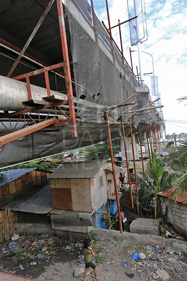 A net installed by the contractor who will rehabilitate the Mandaue-Mactan Bridge is the only thing that separates settlers from objects that might fall once repair begins. (CDN PHOTO/JUNJIE MENDOZA)