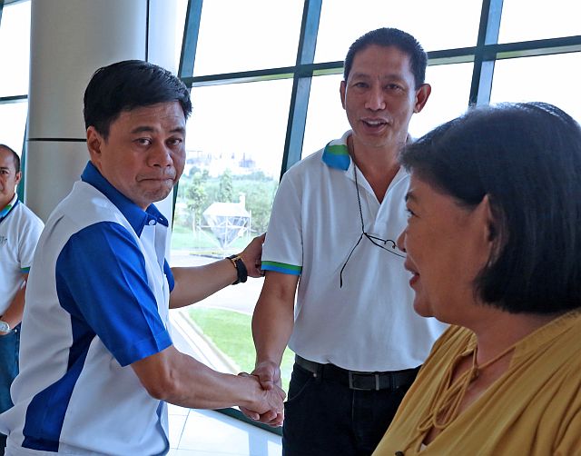 Regional Director Ador Canlas of the Department of Public Works and Highways (DPWH-7) shakes the hand of acting general manager Engr. Noel Danela (center) and Angelie Alonzo (right), vice president of Jegma Construction and Development Corp. after their closed-door meeting at the DPWH regional office. (CDN PHOTO/JUNJIE MENDOZA)