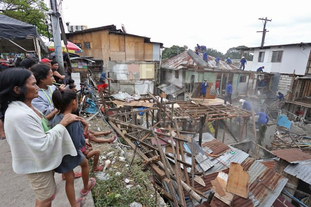Some settlers watch hopelessly as their houses on M. Velez St. in Sitio Sta. Cruz, Barangay Capitol Site are dismantled by City Hall's Probe team. (CDN PHOTO/JUNJIE MENDOZA)