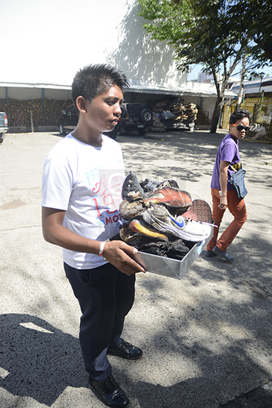 Security guard Jefrey Bitos shows what's left of the Nike shoes that were burned last Friday at the coliseum's parking lot. (CDN PHOTO/CHRISTIAN MANINGO)