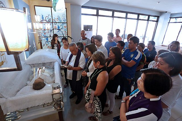 THADEO OUANO'S WAKE/FEB. 27, 2016: Retired Bishop Antonio Rañola blesses the body of late Provincial Board member Thade"Teddy" Ouano at St. Peters Chapel. with Bishop Rañola were Thadeo's wife Glenda (to Rañola's left front row) daughter Mandaue City councilor Lolypop Ouano (far left) son Jonkie Ouano (back to Rañola in white polo shirt) and their relatives in St. Peter's Chapel Mandaue City.(CDN PHOTO/JUNJIE MENDOZA)
