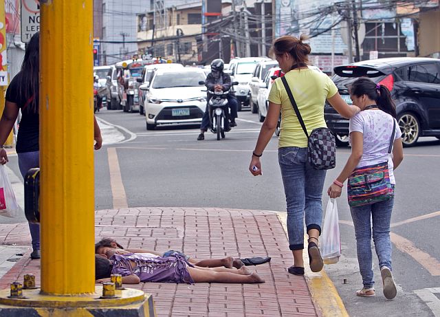 SILOYS WATCHING MANGO STREET CHILDREN/FEB.10,2016:A passeng pedestrian watch these children sleep in the side walk of Mango avenue despite the effort of the Cebu City government to rescue them they continue make the sidewalk their home.Attention DSWD on these.(CDN PHOTO/LITO TECSON)