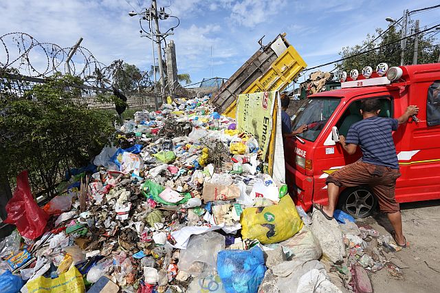 SILOY IS WATCHING: Rocky Dumpa prepare to move away his passenger multicab vehicle away from a mountain of garbage that occupied the sidewalk along sitio Sta Cruz barangay Guizo. Dumpa said that the garbage is been their for a month already. ATTENTION: MANDAUE CITY PUBLIC SERVICES ITS BETTER TO HELP THE BARANGAY TO COLLECT THE GARBAGE.