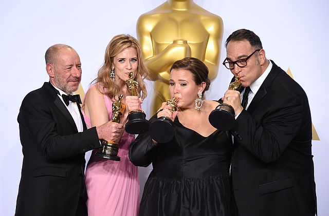 Steve Golin, from left, Blye Pagon Faust, Nicole Rocklin and Michael Sugar, winners of the award for best picture for Spotlight pose in the press room at the Oscars on Sunday, Feb. 28, 2016, at the Dolby Theatre in Los Angeles. (Photo by Jordan Strauss/Invision/AP)
