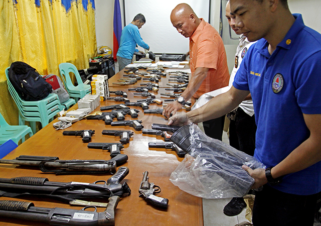 Police officials show the various firearms that were seized in Tabuelan town, northern Cebu last Tuesday. (CDN PHOTO/LITO TECSON)