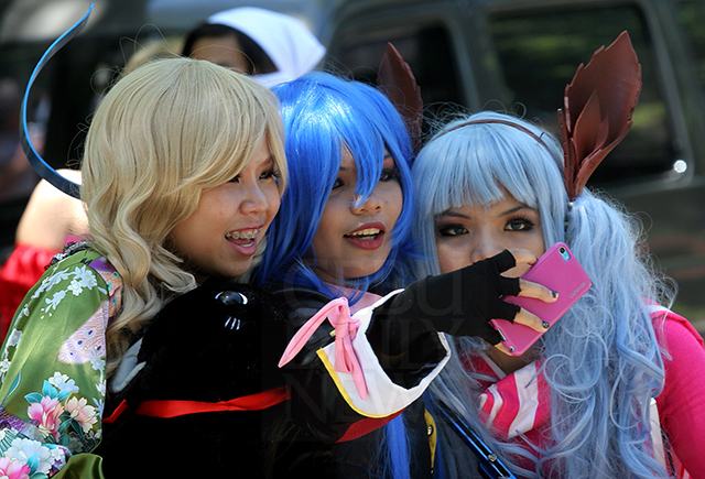 Three friends in their anime costume takes a selfie at the UP Cebu grounds. (CDN PHOTO/JUNJIE MENDOZA)