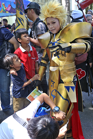Two young boys watch as a csoplayer gets help in fixing his costume during the OtakuFest9. (CDN PHOTO/JUNJIE MENDOZA)