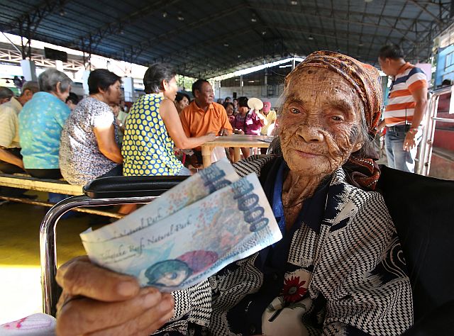 SENIOR CITIZENS FINANCIAL ASSISTANCE/FEB. 12, 2016: 98-year-old Maxima E. Totoy (on a wheelchair) Senior Citizens of sitio Lahing-Lahing barangay Mabolo smile as she recieves her first P2,000 of the P12,000 a year financial assistance from the Cebu City government.(CDN PHOTO/JUNJIE MENDOZA)