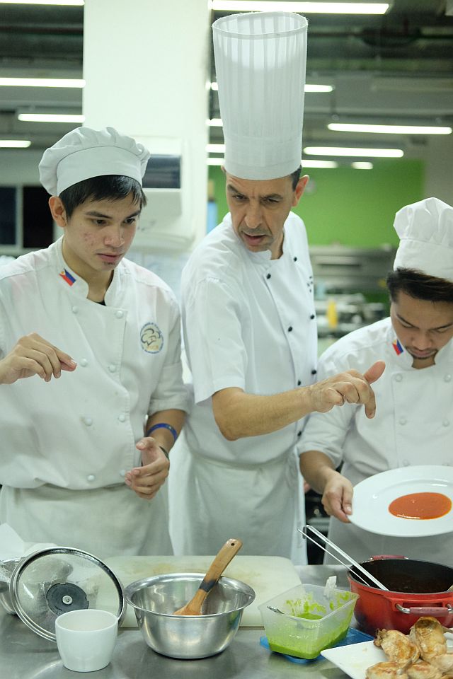 AFTER A  DEMONSTRATION  by Chef Hicham  Merouane (center), students John  Meynard Ricarte  and Emmanuel Roble replicate his plating precisely. The batch prepared three menus: Italian, Greek and South American for their annual  International Cuisine class graduation  exam.