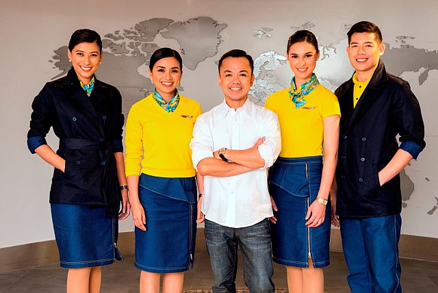 JUN Escario  flanked by the many variations of the new cabin crew uniforms for Cebu  Pacific Air. The models, by the way, are real stewards and flight attendants  of the airline.