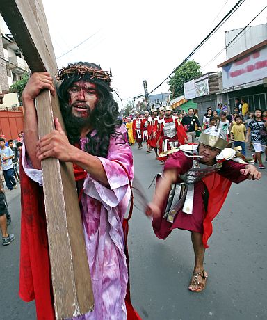  An actor dressed as a Roman soldier whips the actor playing Jesus Christ as part of the annual ‘Buhing Kalbaryo’ reenactment from San Nicolas Church to the Guadalupe Church. (CDN FILE PHOTO)
