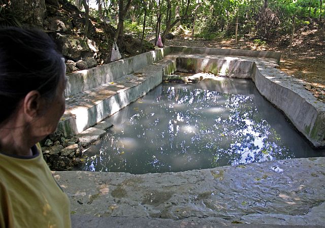 A resident of Barangay Pitalo, San Fernando shows the murky waters of Lacaron Spring. The spring is located near the pile of coal that residents blame for their respiratory problems. (CDN PHOTO/LITO TECSON)
