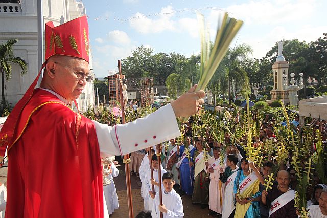 Archbishop Jose Palma (left) blesses the palms brought by churchgoers, who attended yesterday’s Palm Sunday Mass at the Cebu Metropolitan Cathedral. At right, Palma enters the Cebu Cathedral to celebrate Mass. (CDN PHOTO/SAMMY NAVAJA)