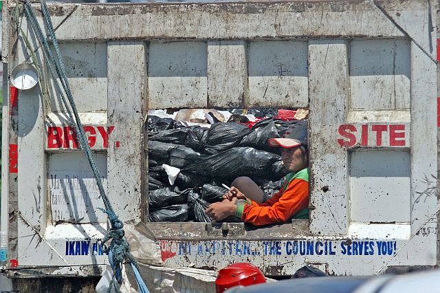 SILOY IS WATCHING: A garbage collector is like seating on his house window smoking but he is seating inside a garbage truck unaware of the heath hazard while he is inside the truck full of garbage. ATTENTION: CAPITOL SITE BARANGAY CAPT. MANUEL GUANZON LETS NOT WAIT FOR THIS BARANGAY WORKERS TO BE HOSPITALIZE