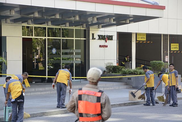 FIRE HITS LEXMARK PLAZA1 BLDG./MAR. 10, 2016 A fire hit the 22nd floor of Lexmark Plaza 1 in Cebu Business Park. General services crew clean up scatterd broken glass outside the building. (CDN PHOTO/CHRISTIAN MANINGO)