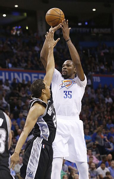 Oklahoma City Thunder forward Kevin Durant shoots over San Antonio Spurs guard Andre Miller in the second quarter of an NBA basketball game in Oklahoma City. (AP)