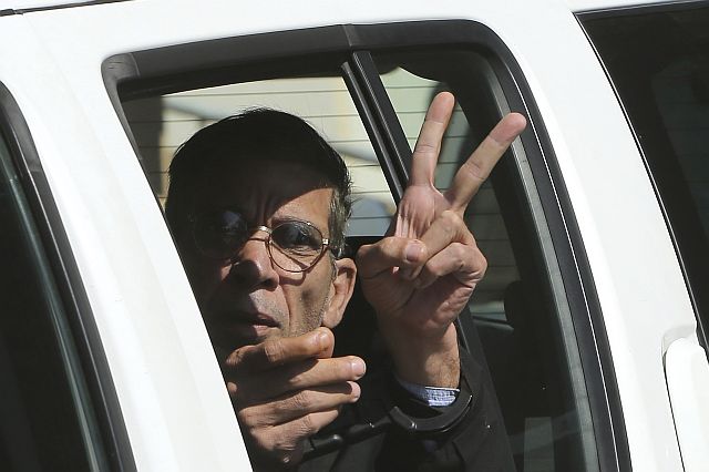 EgyptAir plane hijacking suspect Seif Eddin Mustafa flashes the victory sign as he leaves a court in a police car after a remand hearing in the Cypriot coastal town of Larnaca. (AP)