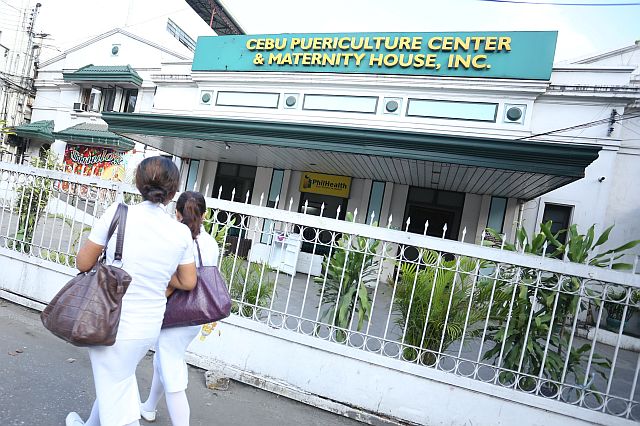 Two unidentified person pass outside the Cebu Puericulrure Center and  Maternity House Inc that was just open..(CDN PHOTO/Lito Tecson)