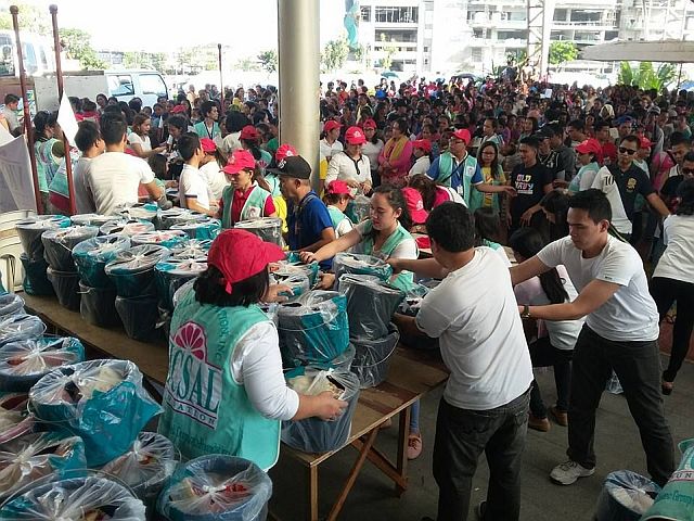 The staff of Vicsal Foundation and Metro Retail Stores Group prepare the pails containing relief goods for distribution to the fire victims at the Cebu International Convention Center. (CONTRIBUTED)