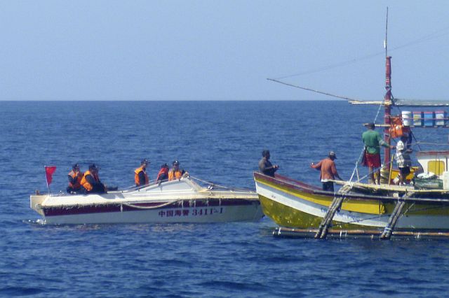 In this Feb. 27, 2015 photo provided by Renato Etac, Chinese Coast Guard members approached Filipino fishermen near Scarborough Shoal in the South China Sea. More than once, Chinese Coast Guardsmen approached Etac’s boat and pointed their rifles at him, but he knew they would not fire and start a war. (AP)