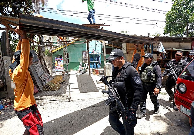APAS SITIO SAN MIGUEL DEMOLITION/APRIL 04,2016:SWAT personel pass one of the demolish house in sitio San Miguel Barangay Apas.(CDN PHOTO/LITO TECSON)