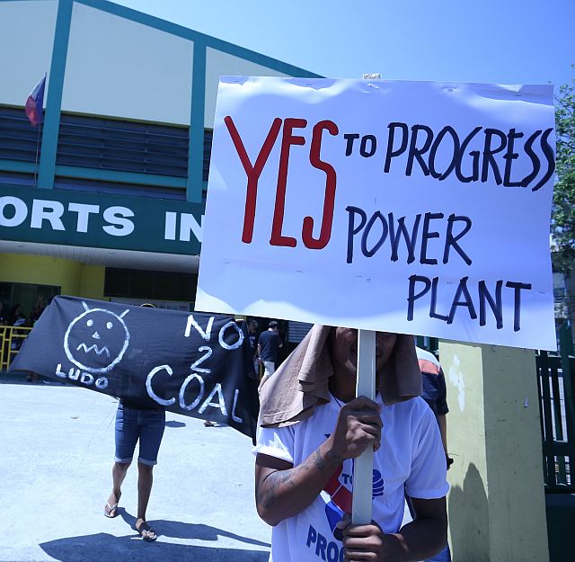 COAL PLANT: A backer and opposer of the coal-fired power plant display their sentiments during a public hearing. The Cebu City Council has scheduled another meeting for all stakeholders tomorrow, Friday. (CDN PHOTO/LITO TECSON)