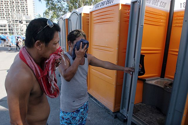 SMELLY PORTALETS/APRIL 25, 2016: Barangay Guizo and Mantuyong fire victims who were temporary occupied the Cebu International Convention Center (CICC) grounds cover their noses as they show the smelly portalets they compalint because alledgely it was only clean up one's a week.(CDN PHOTO/JUNJIE MENDOZA)