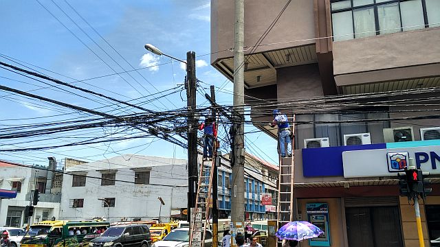 Personnels from a utility company are busy concealing wires at the corner of D. Jakosalem and Legaspi Street in downtown cebu city. (CDN PHOTO/CHRISTIAN MANINGO)