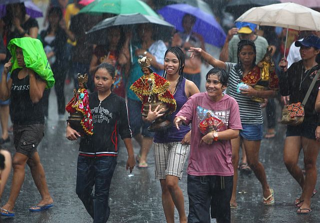 PROCESSION/JAN 15,2011: Devotees brave the rain during the Sto Nino procession that passes Fuente Osmena.(CDN PHOTO/TONEE DESPOJO)