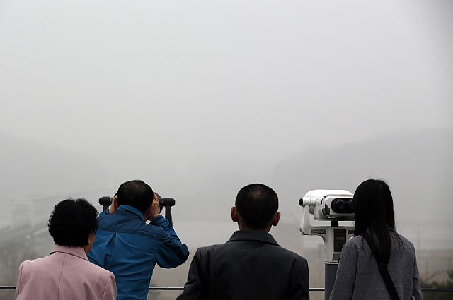 Visitors look at the North side on a foggy day at the Imjingak Pavilion near the border village of Panmunjom in Paju, South Korea. North Korea says it has successfully tested a new intercontinental ballistic rocket engine. (AP)