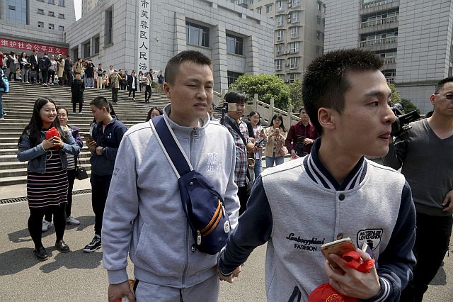 Sun Wenlin (right) and his partner Hu Mingliang leave the court after a judge ruled against them in China’s first gay marriage case. (AP)
