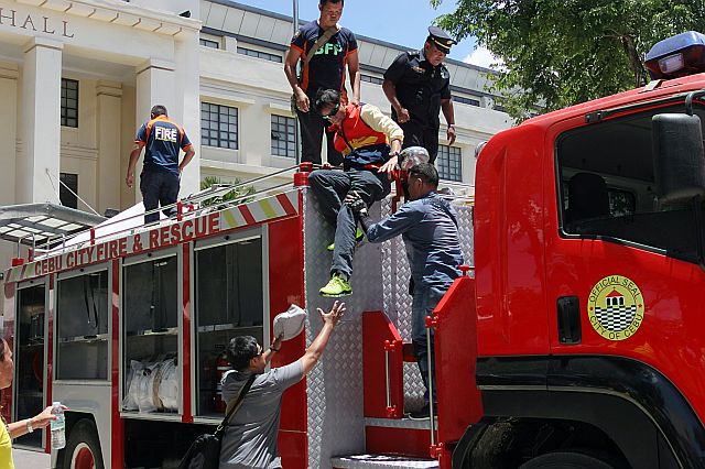 Mayor Michael Rama receives a helping hand from BFP personnel as he steps off from the new fire truck after conducting an inspection. (CDN PHOTO/ JUNJIE MENDOZA)