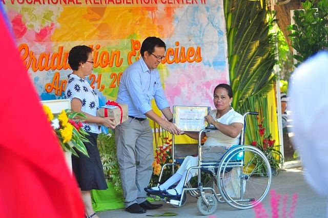 DSWD 7 Assistant Regional Director for Administration Marcial Fernandez (center), assisted by Area Vocational Rehabilitation Center  head Sheba Dabon, gives a certificate of completion to a PWD trainee. (CONTRIBUTED) 